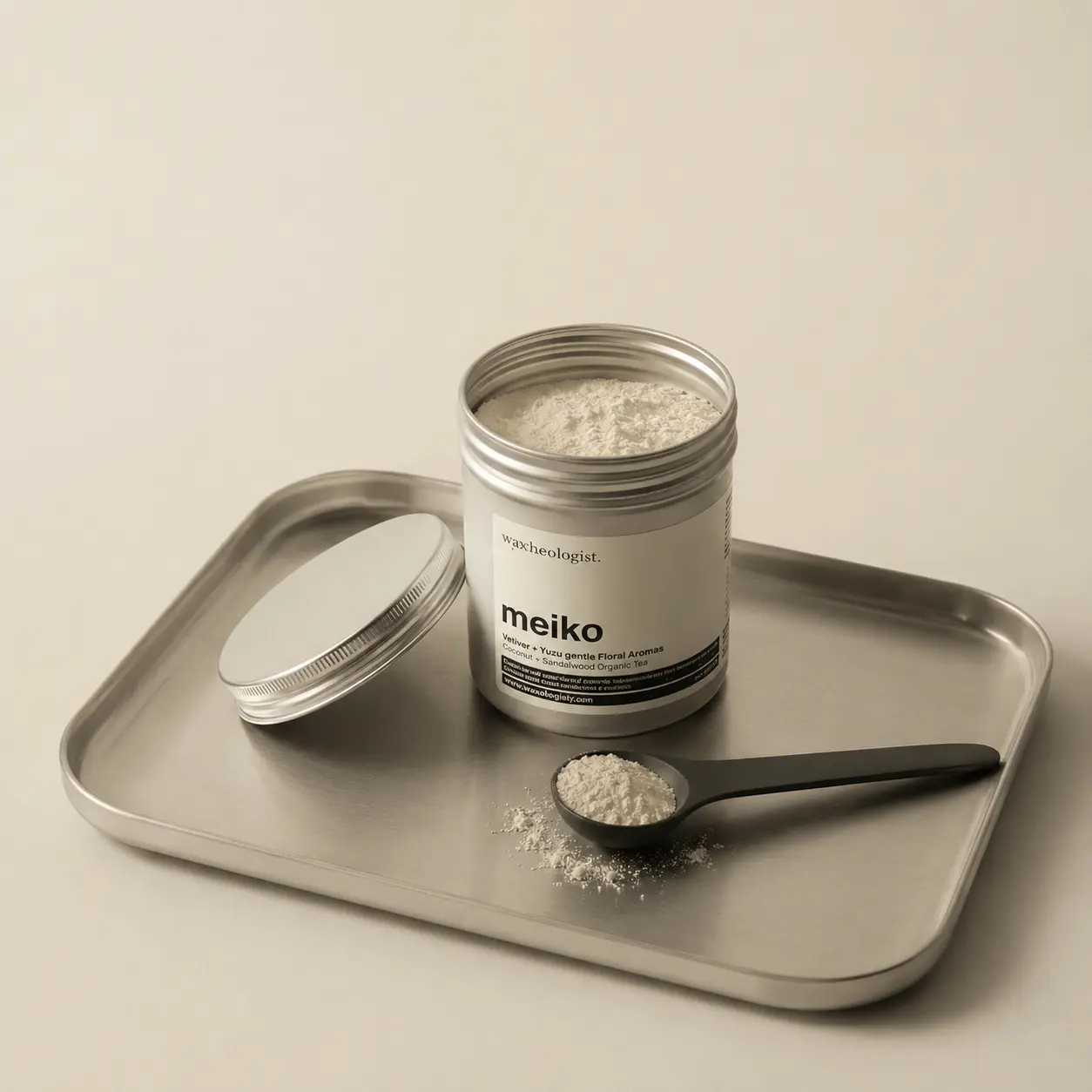 Open Meiko matcha tin and scoop arranged on a softly lit metal tray