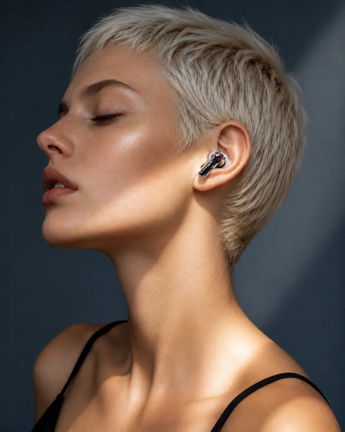 Calm editorial portrait featuring a transparent wireless earbud