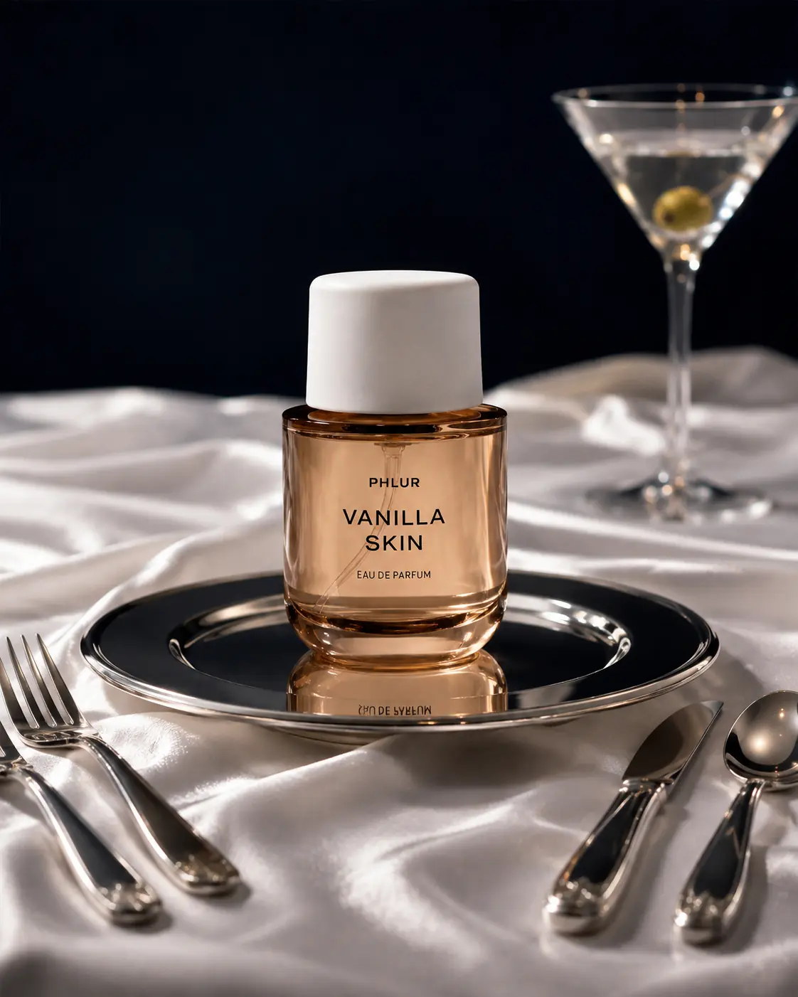 Fragrance bottle set on a silver table beside a martini glass
