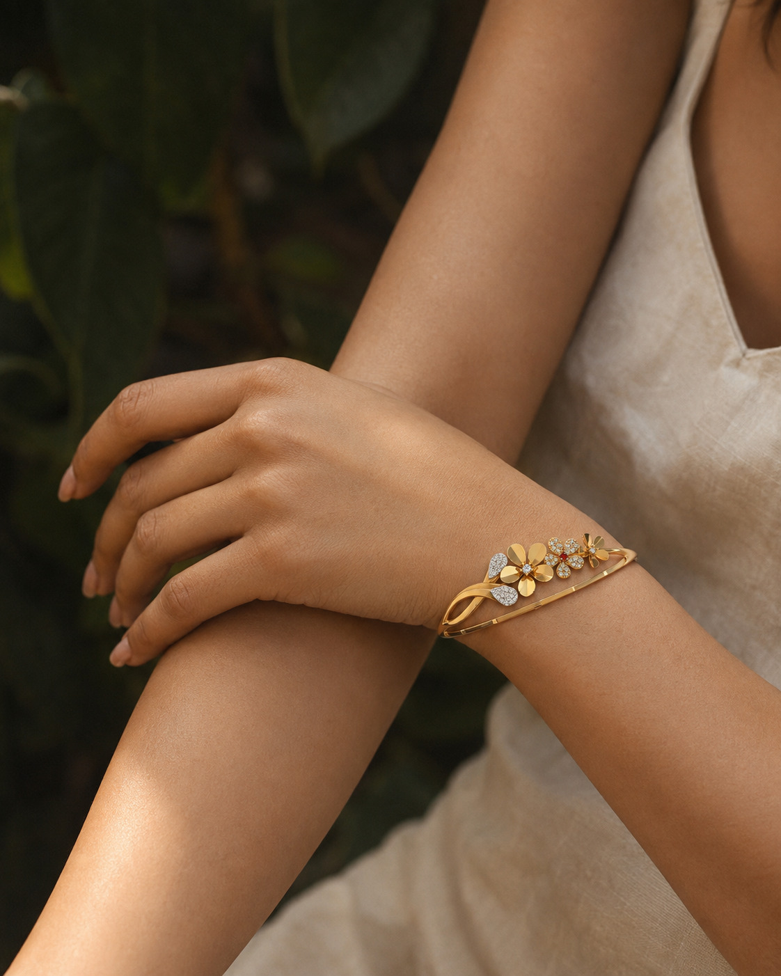 Floral gold bracelet showcased on crossed wrists in a soft editorial setting