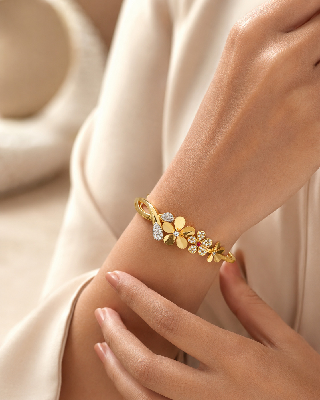 Floral gold and diamond bracelet styled against flowing ivory fabric